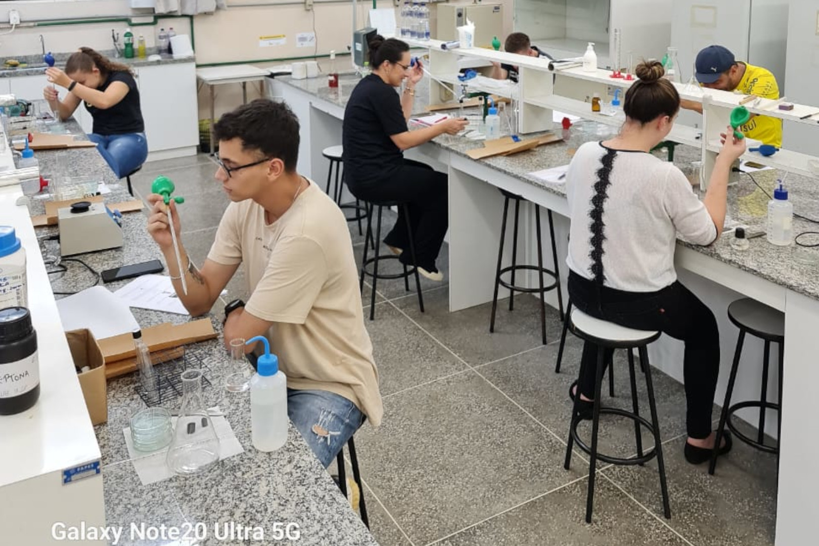 Estudantes do Curso Tecnlogo em Gastronomia manuseando vidrarias e preparando materiais para anlises microbiolgicas em laboratrio